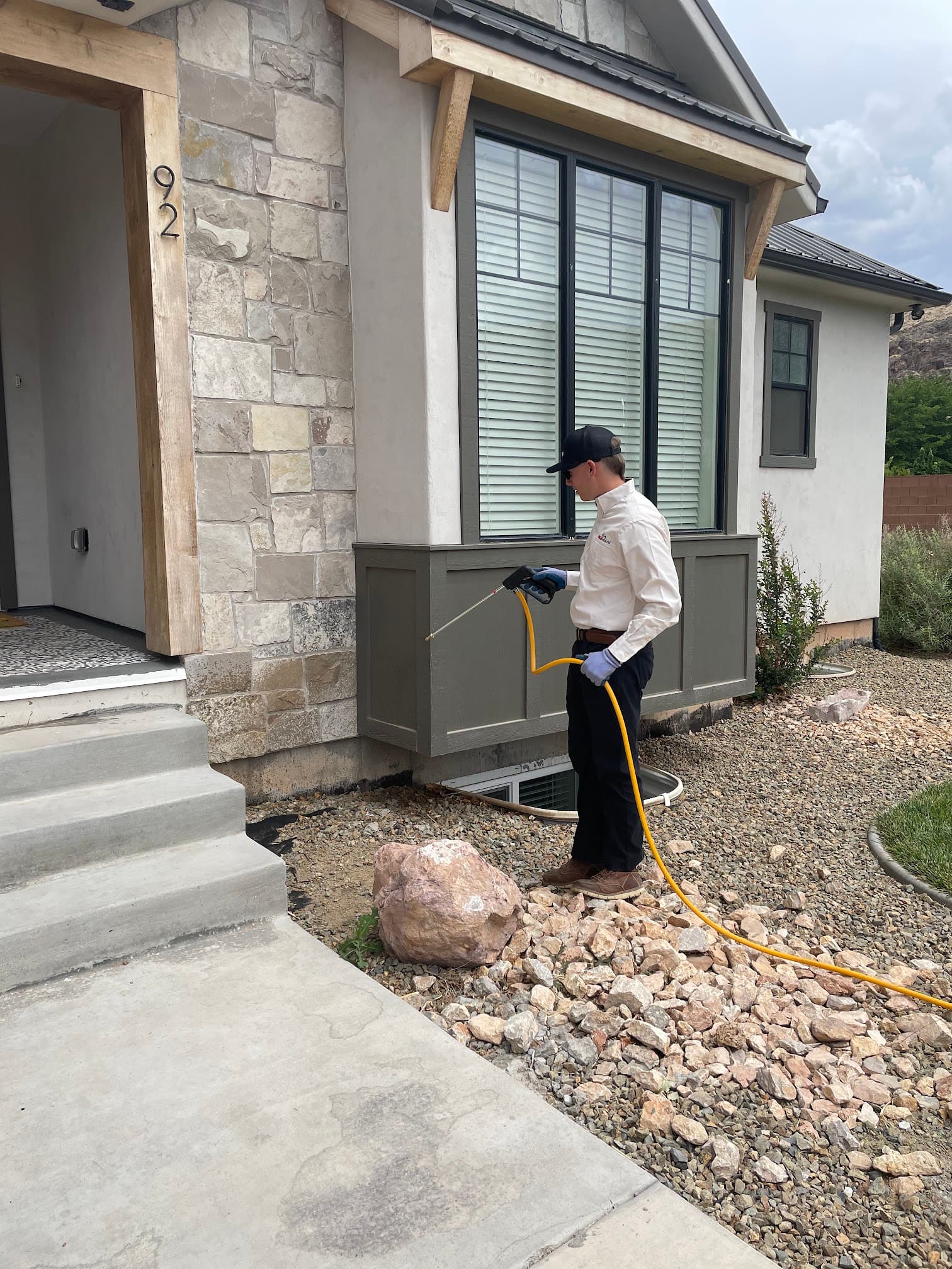 Bugman technician treating a home's exterior